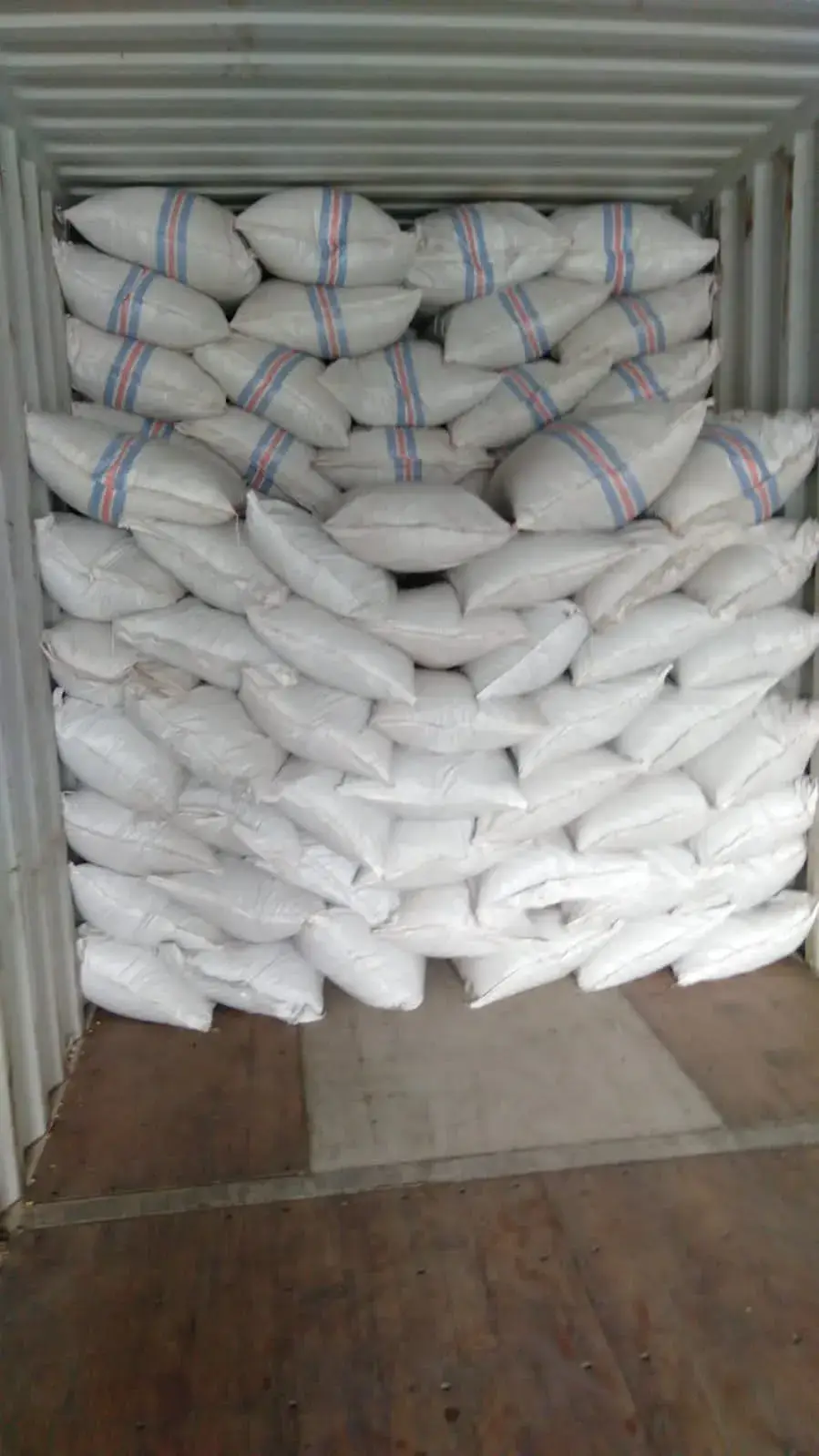 Filled sacks stacked to the roof inside a container.