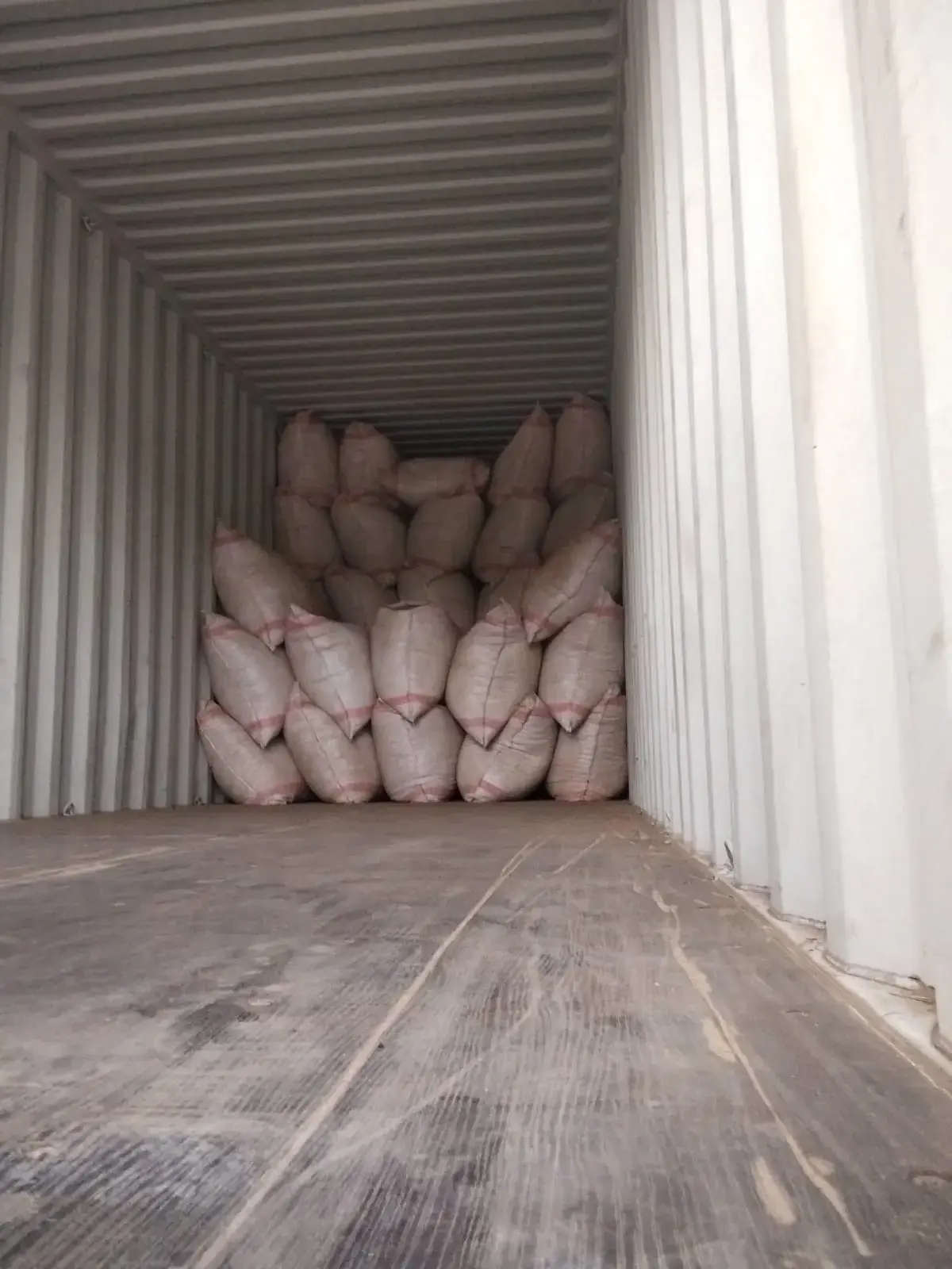 A container part-loaded with sacks, floor visible in front.