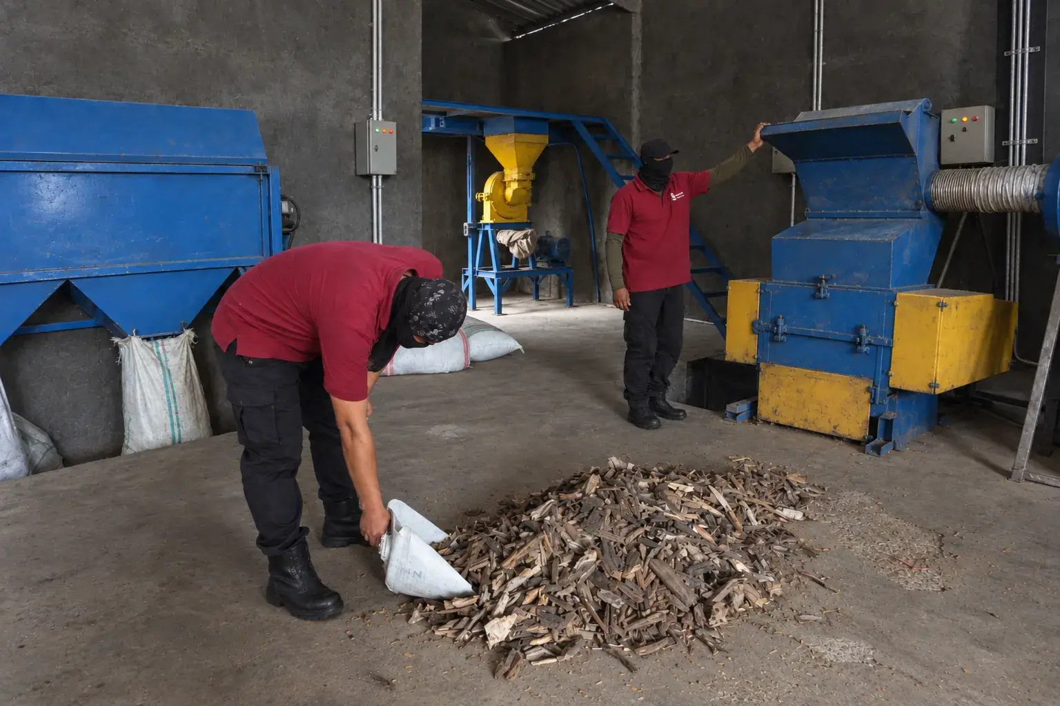 Two of the team at the mill, bagging chipped material as it comes off the machine.