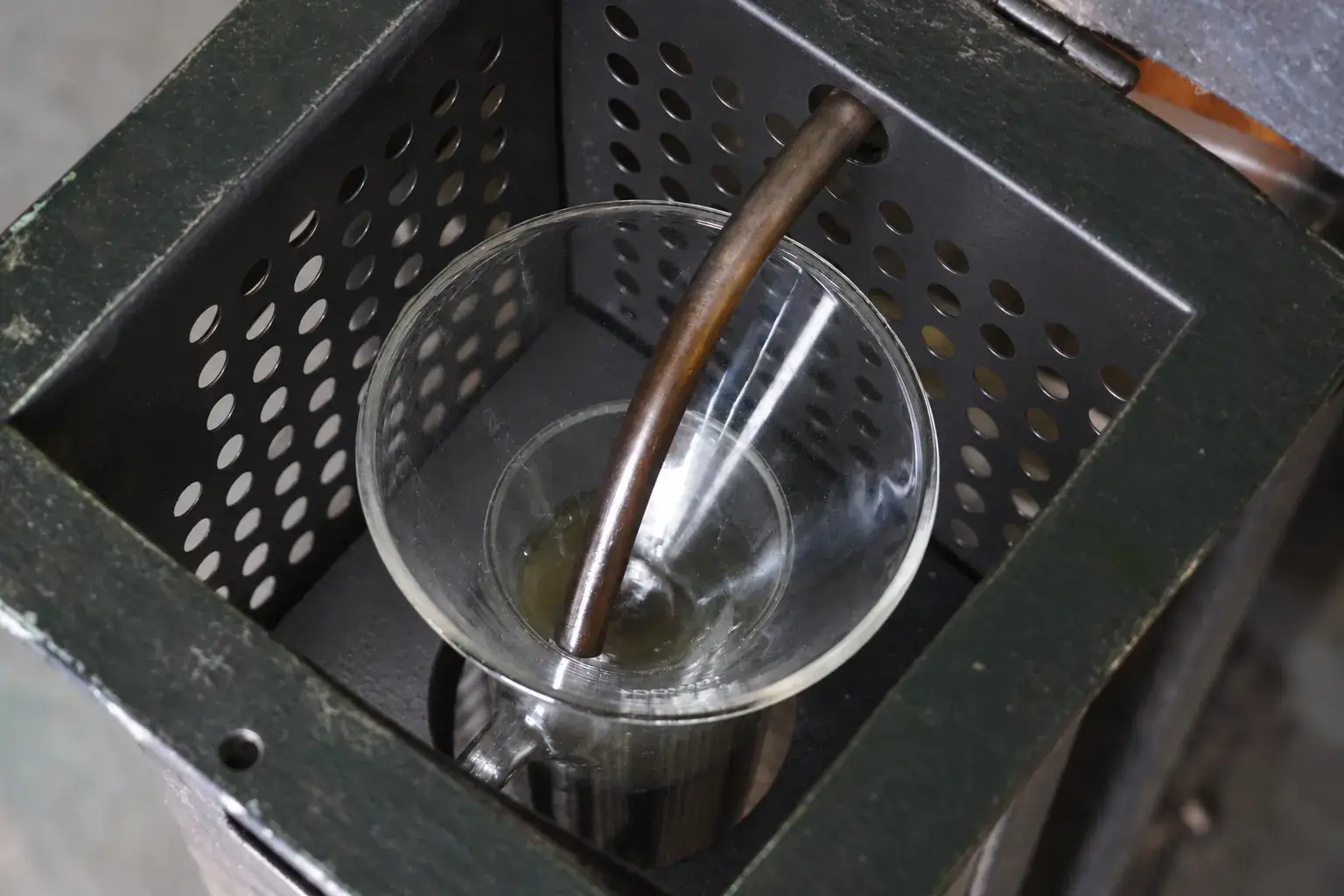 Distilled oil running from the still into a glass beaker.