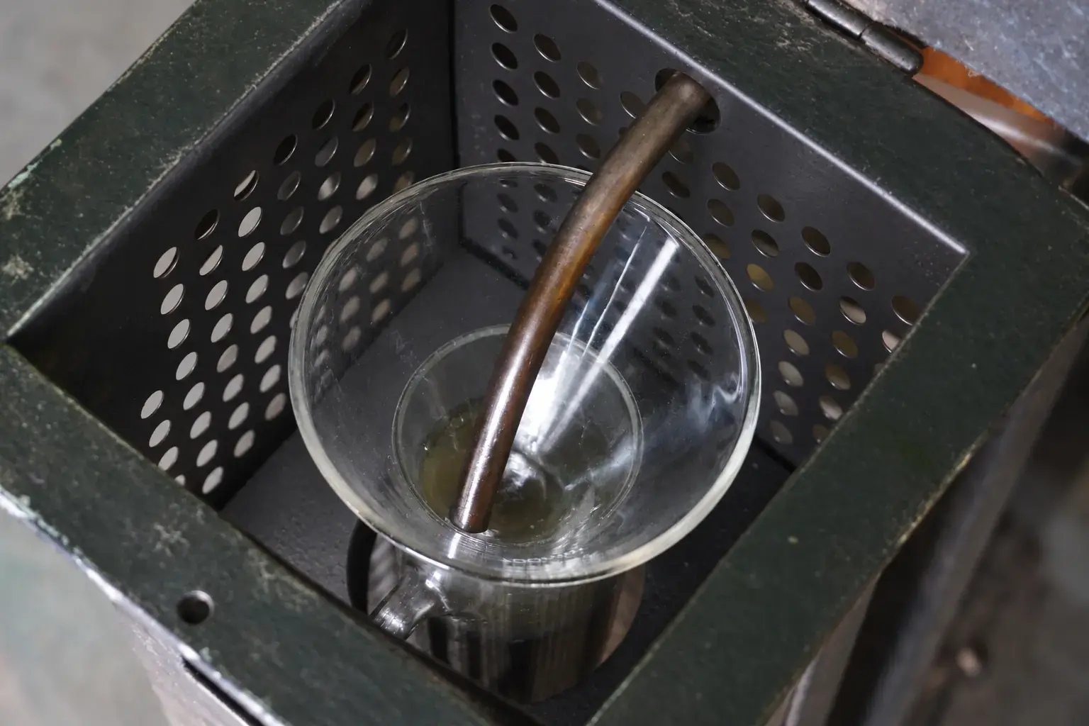 Distilled oil running from the still into a glass beaker.